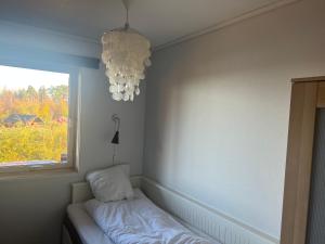 um quarto com uma cama, uma janela e um lustre em Buvika Panorama 