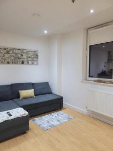 a living room with a blue couch and a window at Amazing Canterbury 1 BR Flat in London CB54 in Croydon