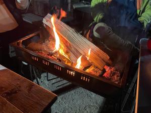 un hombre está cocinando comida sobre una parrilla con llamas en Biwako Hills Resort - Vacation STAY 99556v en Takashima