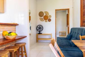 - un salon avec un canapé bleu et une table dans l'établissement Condomínio aconchegante a 300mt da Praia de Barra Grande, à Barra Grande