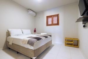 - une chambre avec un lit et une fenêtre dans l'établissement Condomínio aconchegante a 300mt da Praia de Barra Grande, à Barra Grande