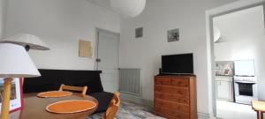 a living room with a table and a tv at Eole in Wimereux +5 photos