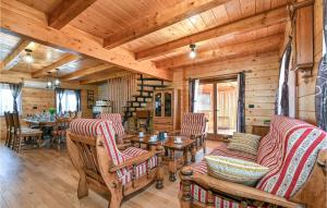 a log cabin living room with wooden ceilings and tables and chairs at Lovely Home In Vinogradi Ludbreski With Kitchen in Ludbreg