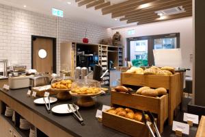 a bakery with a counter with various types of bread at Holiday Inn Express Fürth, an IHG Hotel in Fürth