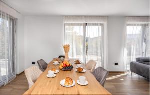 a dining room with a wooden table with food on it at Awesome Home In Stari Laz With Wi-Fi in Stari Laz +19 photos