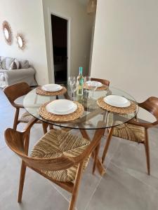 une salle à manger avec une table et des chaises en verre dans l'établissement Arena Coral - Main Street - 50m Beach, à Corralejo
