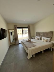 a bedroom with a large bed and a large window at Arena Coral - Main Street - 50m Beach in Corralejo