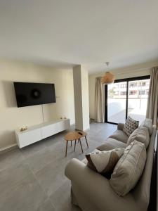 a living room with a couch and a tv at Arena Coral - Main Street - 50m Beach in Corralejo