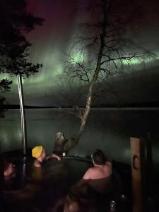 a group of people in a bathtub with a tree at Palojärven Lomakeskus in Sonka