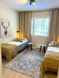 1 dormitorio con 2 camas y ventana en Palojärven Lomakeskus en Sonka
