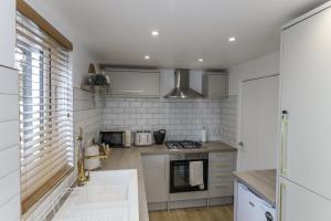 a kitchen with white walls and a stove top oven at Oasis Retreat Hot Tub Cupar in Cupar