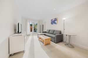 a living room with a couch and a table at Molesey Apartments in East Molesey