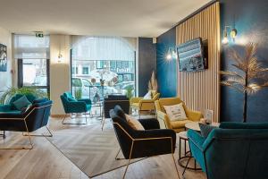 a lobby with couches and chairs in a room at The Originals City, Hôtel Les Océanes, Lorient in Lorient