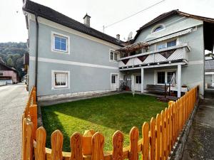 a fence in front of a house with a yard at Ferienwohnung Pufitsch in Gmünd in Kärnten