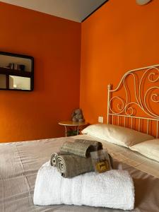 a bedroom with two beds with orange walls at Borgo Lungofiume B&B in Valbrenta 