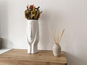 a white vase with flowers sitting on a table at Apartment mit großem Balkon in Hannover Nordstadt in Hannover