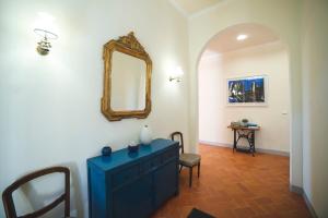una stanza con un comò blu e uno specchio di Casa villa familiare. Il Canto dei Poeti a Fiesole