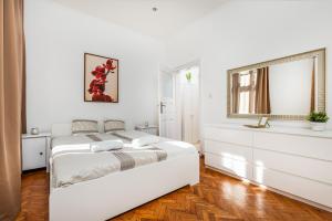 ブダペストにあるReal Apartments Andrássyの白いベッドルーム(ベッド1台、窓付)