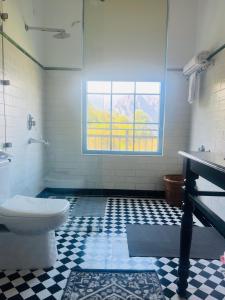 bagno con servizi igienici e finestra. di Faraway Cottages, Auli a Joshīmath