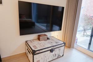 an old trunk sitting in a room with a tv at White Casa in Seogwipo