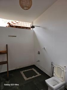 a white bathroom with a toilet in a room at Agonda Beach Villa in Agonda