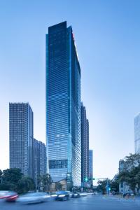 a tall building with cars in front of a city at Hamps Hotel ShenZhen in Shenzhen