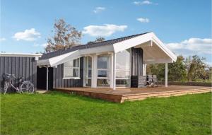 una casa con terrazza e tenda da sole bianca di Gorgeous Home In Or With Kitchen a Orø