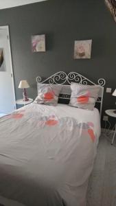 una camera da letto con un grande letto con lenzuola e cuscini bianchi di La maison de Zélie a Larnagol