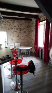 una habitación con sillas rojas y una mesa en una habitación en La maison de Zélie, en Larnagol