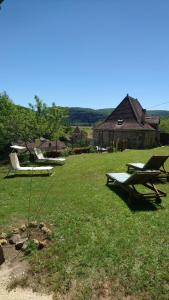 un campo con dos mesas de picnic en el césped en La maison de Zélie, en Larnagol