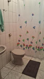bagno con servizi igienici e tenda doccia con uccelli. di Casa Caraguatatuba Nelson a Caraguatatuba