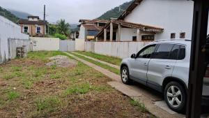 un coche aparcado frente a una casa en Casa Caraguatatuba Nelson en Caraguatatuba