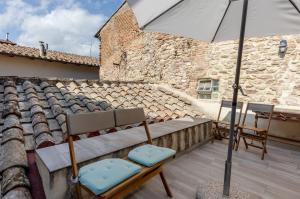 um pátio com duas cadeiras e um guarda-sol no telhado em Charming Terrace House in the heart of Perugia em Perugia