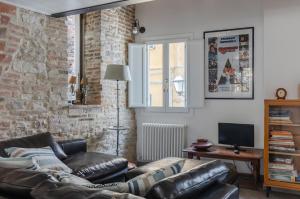 uma sala de estar com um sofá de couro e uma televisão em Charming Terrace House in the heart of Perugia em Perugia