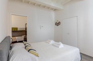 um quarto branco com uma cama e um espelho em Charming Terrace House in the heart of Perugia em Perugia