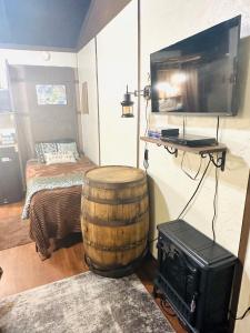 a room with a barrel and a tv and a bed at Acorn Hideaways Canton Escape to Neverland Suite for 3 in Canton
