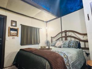 a bedroom with a bed with a blue ceiling at Acorn Hideaways Canton Escape to Neverland Suite for 3 in Canton