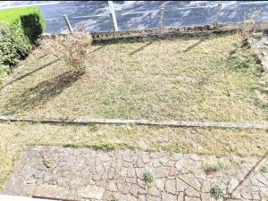 einen Garten mit Gras, einem Zaun und einem Gehweg in der Unterkunft Maison à Aurillac - 3 chambres - Arrivée autonome in Aurillac
