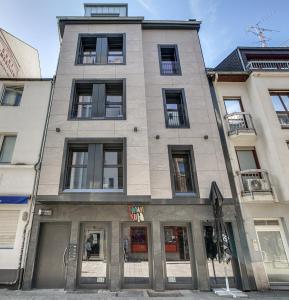 um edifício alto com janelas numa rua em Mont Apartments em Düsseldorf