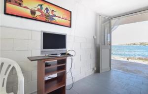 una habitación con TV en un soporte de madera con un tvicteterictericétrico en Gorgeous Apartment In Brucoli With Kitchen, en Brucoli