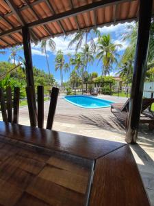 a view of a swimming pool with palm trees at Country Club Pititinga in Pititinga