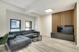 a living room with a couch and a flat screen tv at Mont Apartments in Düsseldorf
