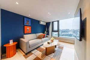 a living room with a couch and a large window at Livetour Hotel Sanxi Metro Guangzhou in Guangzhou