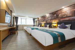 a row of four beds in a hotel room at Amemouillage Inn - Guangzhou Railway Station Xicun Metro Station in Guangzhou