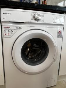 a white washing machine in a kitchen at Flat in London in London