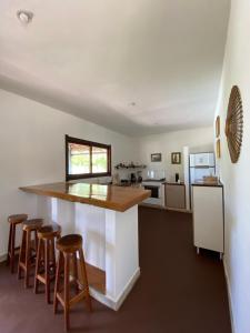 a kitchen with a counter and bar stools at Country Club Pititinga in Pititinga