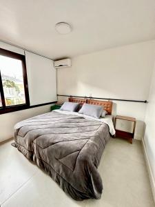 - une chambre avec un grand lit et une fenêtre dans l'établissement Apartamento Artístico - Garagem - Ar Condicionado - Excelente Localização, à Bento Gonçalves