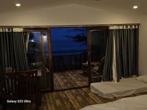 a bedroom with a balcony with a view of the ocean at Agonda Beach Villa in Agonda