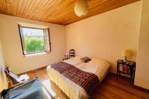 Schlafzimmer mit einem Bett und einem Fenster in der Unterkunft Large family nest with garden in Le Monêtier-les-Bains