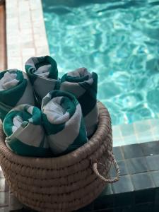 a basket of towels sitting next to a swimming pool at Casa Nina Milagres in São Miguel dos Milagres